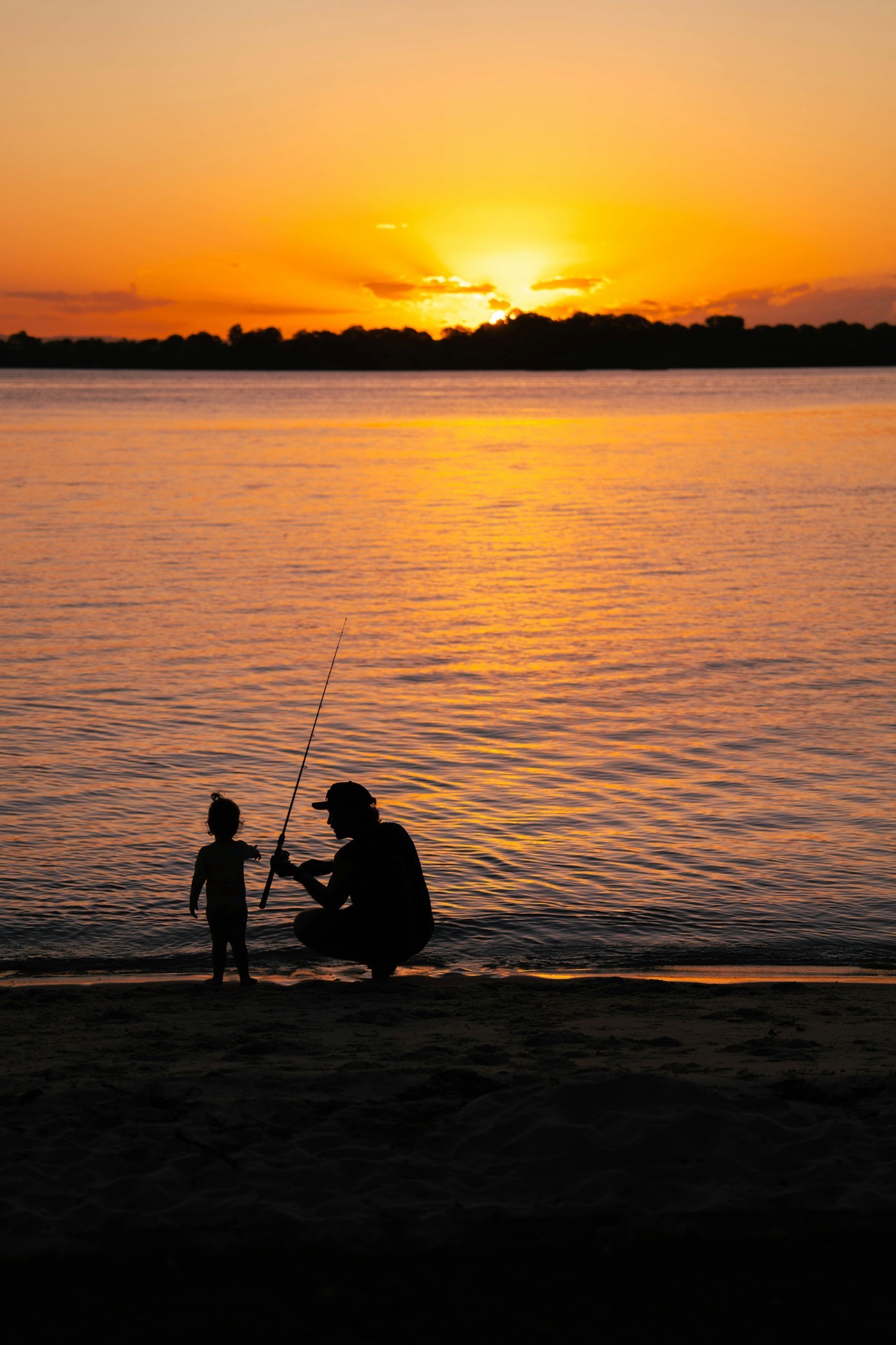 Father and son silhouettes in golden hour light